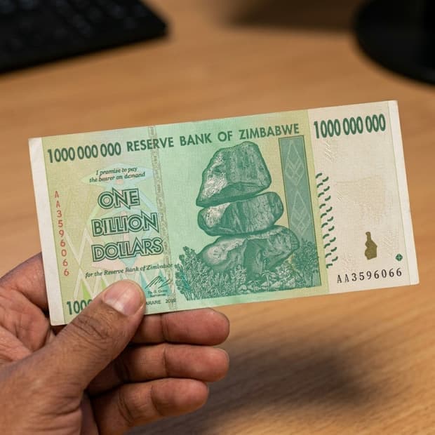 1 Billion note held between fingers for scale