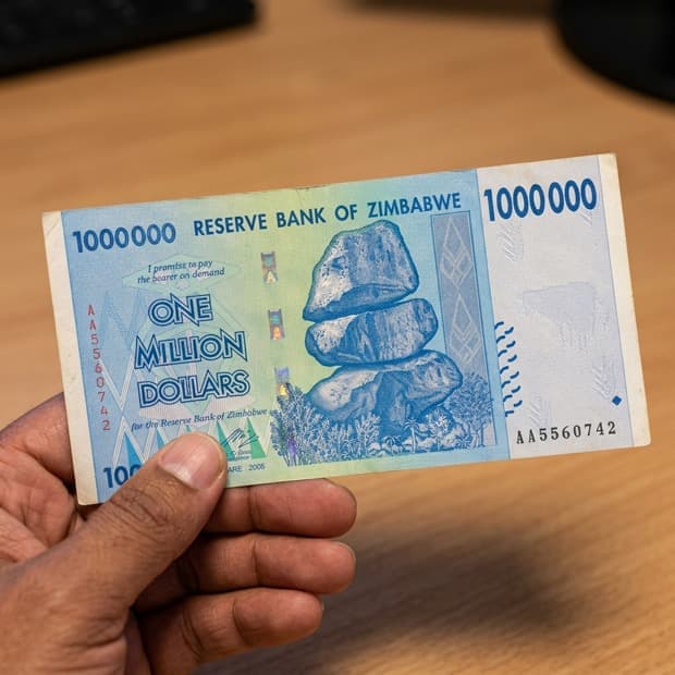 1 Million note held between fingers for scale