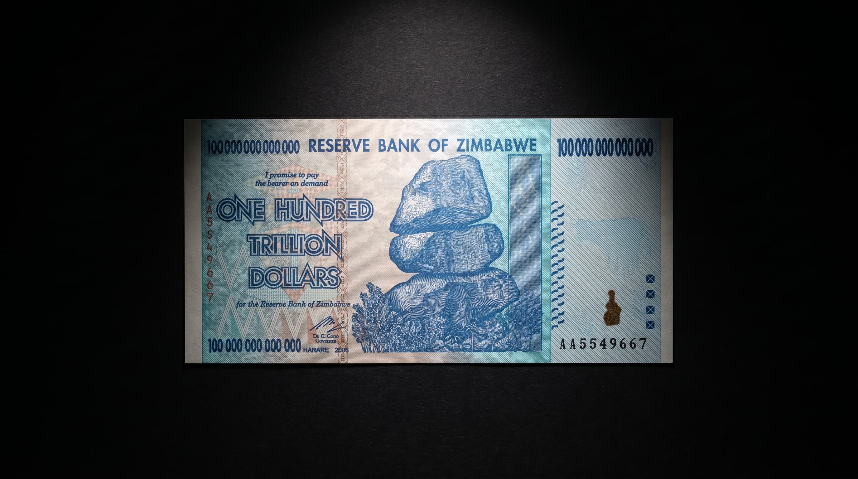 The Zimbabwe 100 Trillion Dollar note presented under museum lighting